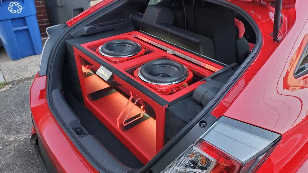 Stealth subwoofer enclosure integrated into a car's trunk