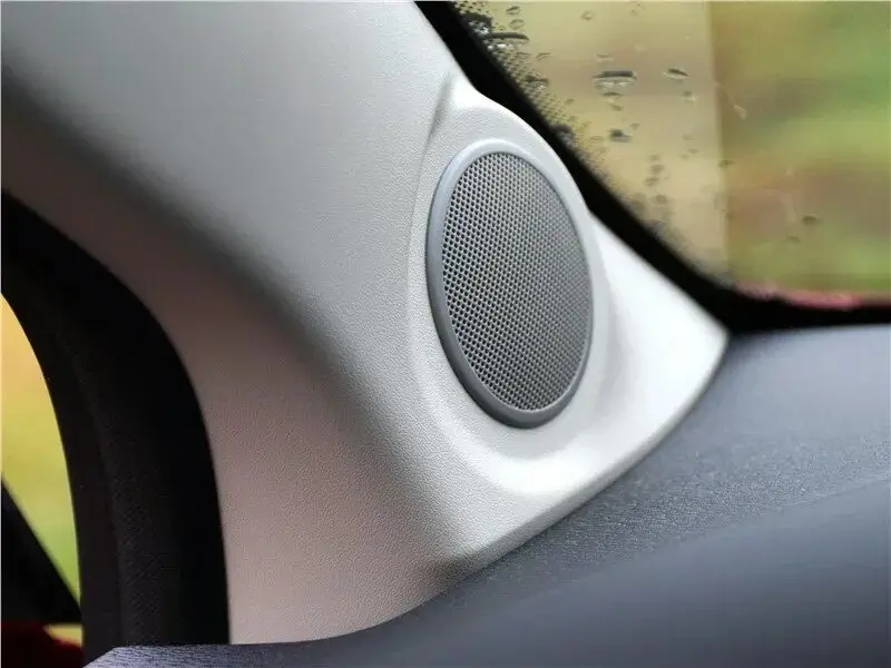 Driver's perspective of a car interior with a focus on the dashboard speakers