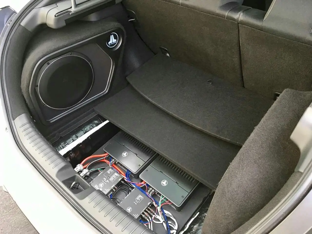 Stealth subwoofer installation hidden in the trunk side panel